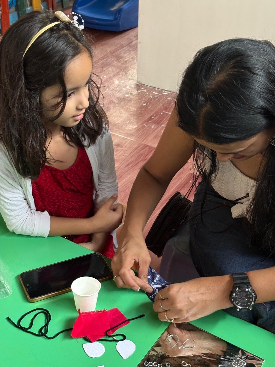 An instructor guiding a young student through a hand-craft project